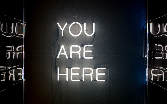 Neon sign that reads "you are here"