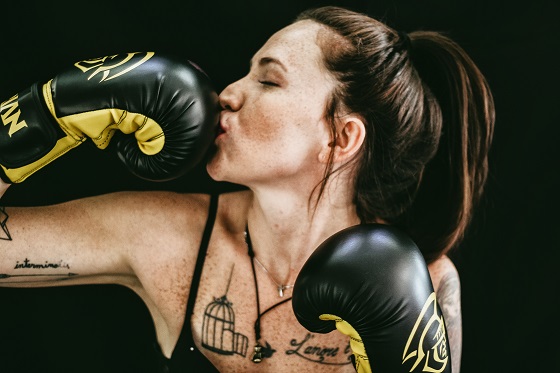 Woman wearing boxing gloves to do sport and looking powerful